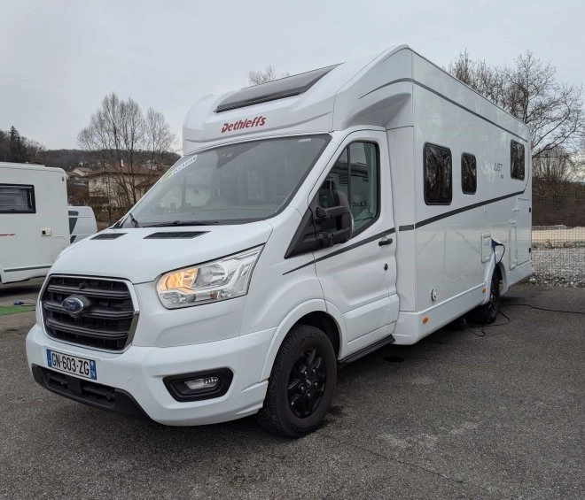 Camping-car Dethleffs blanc stationné sur un parking