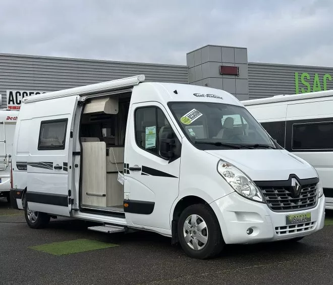 Camping-car Renault blanc stationné devant un concessionnaire