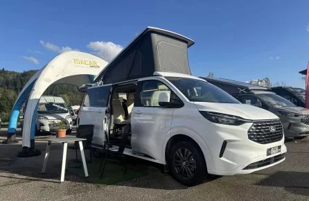 Camping-car Ford blanc exposé chez Isacar sous un ciel bleu