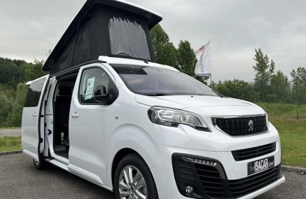 Van Peugeot blanc avec toit relevable sur un parking