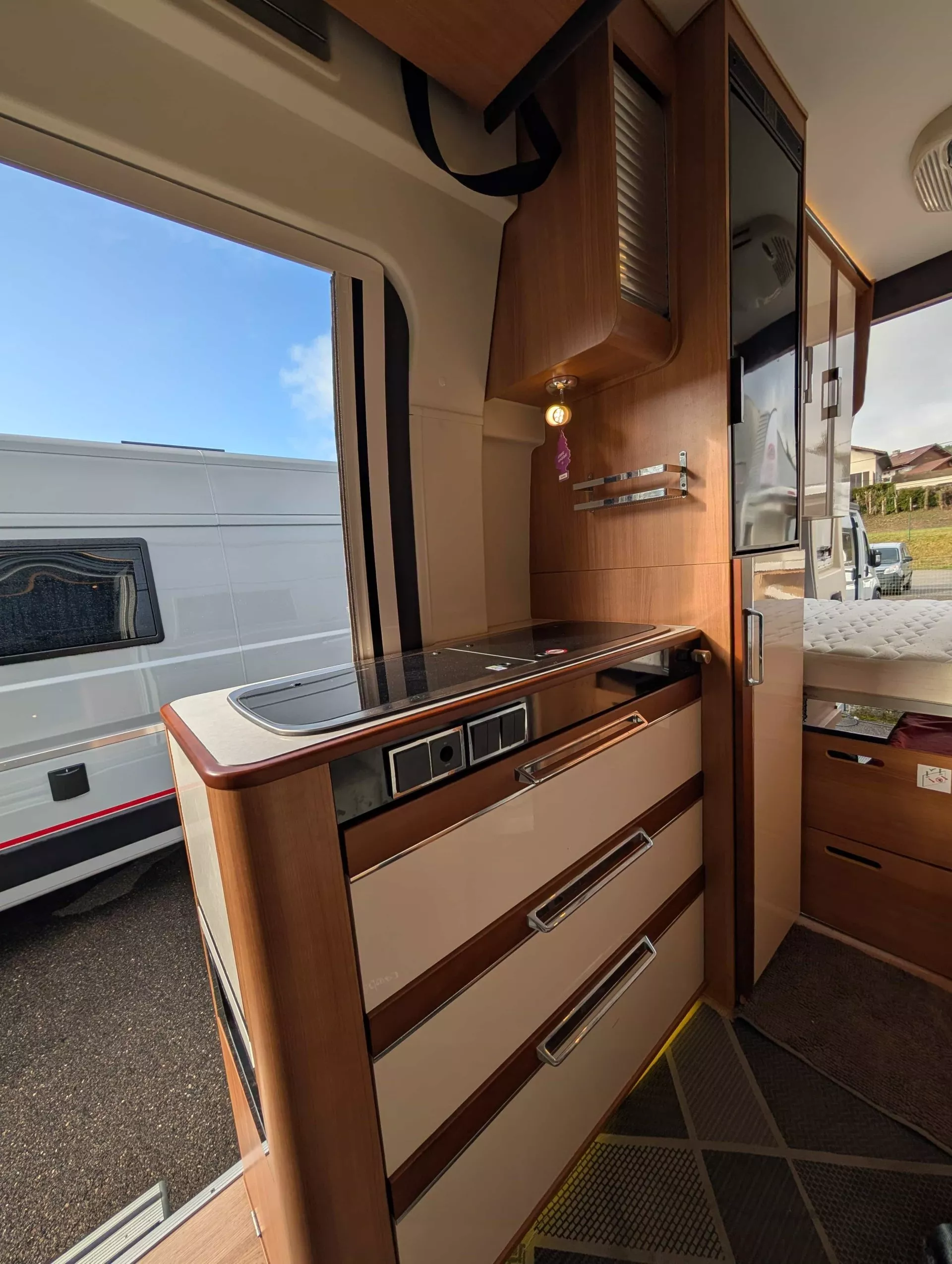 Intérieur d'un camping-car avec cuisine équipée et rangements en bois