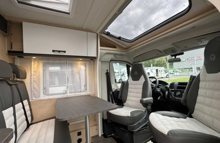 Intérieur moderne d'un camping-car avec sièges et table.