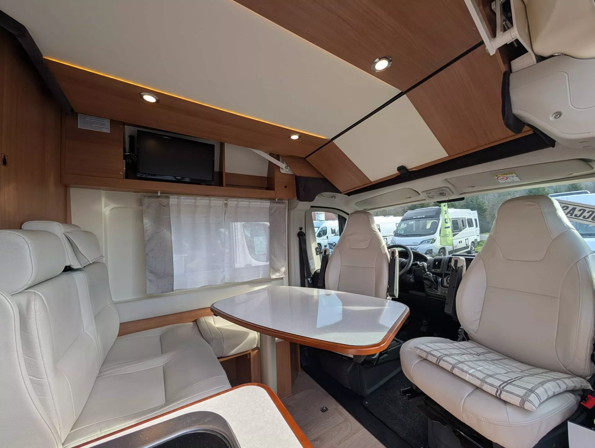 Intérieur d'un camping-car avec table et sièges en cuir beige