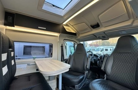 Intérieur d'un camping-car moderne avec sièges en cuir et table pliante