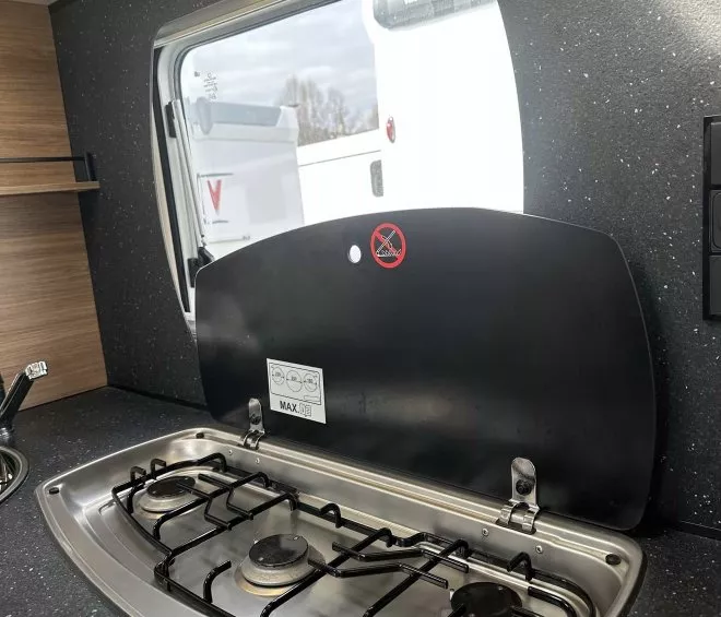 Plaque de cuisson à gaz intégrée dans une cuisine de camping-car moderne.