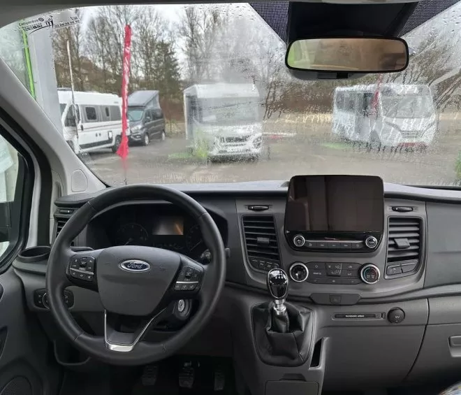 Intérieur d'un véhicule utilitaire Ford avec vue sur le tableau de bord et le volant.
