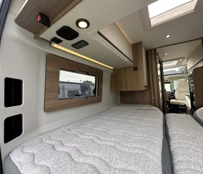 Intérieur d'un camping-car moderne avec lits jumeaux et éclairage intégré
