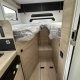 Intérieur d'un camping-car avec lits jumeaux et mobilier en bois clair