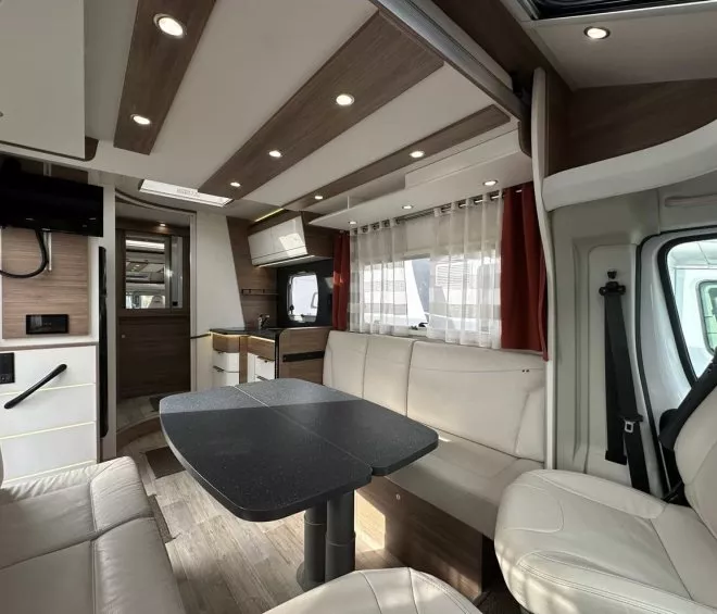 Intérieur moderne d'un camping-car avec salon et cuisine équipée.