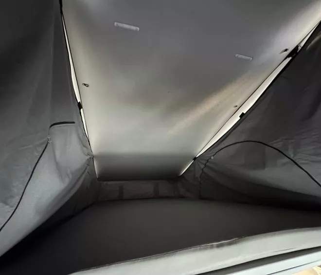 Intérieur d'une tente de toit avec matelas et parois en toile grise