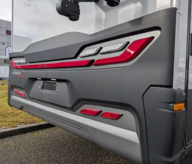 Arrière d'un camping-car Globebus sur un parking, avec feux arrière visibles.