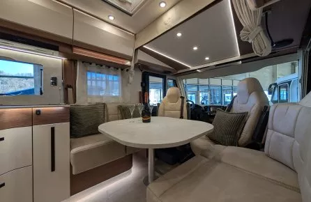 Intérieur spacieux d'un camping-car moderne avec table et sièges en cuir beige