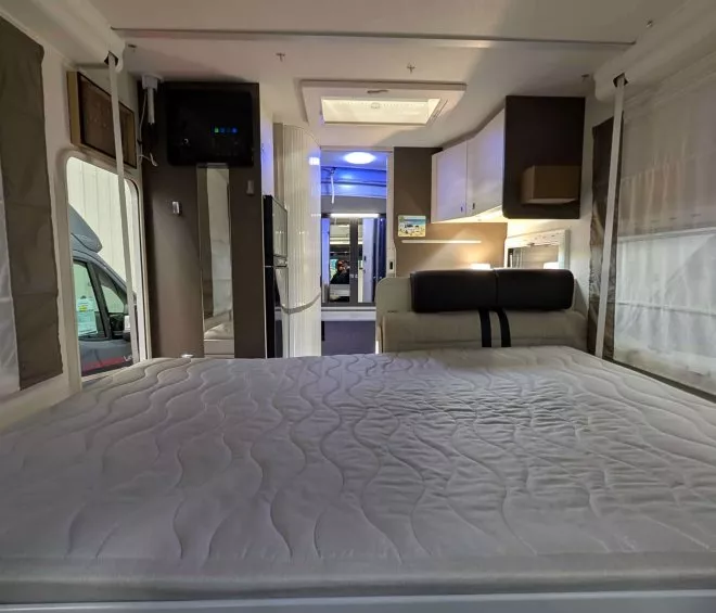 Intérieur d'un camping-car avec lit et espace de vie moderne