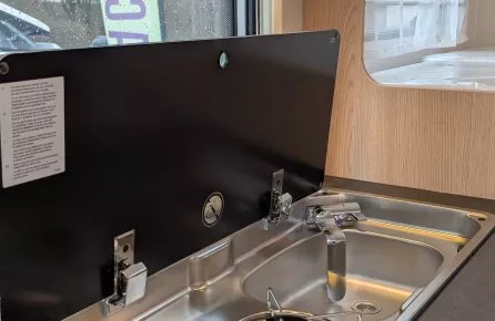 Cuisine intégrée avec plaques de cuisson et évier dans un camping-car moderne.