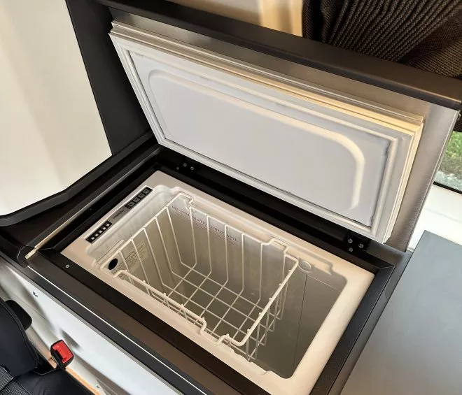 Réfrigérateur intégré dans un véhicule aménagé avec panneau de contrôle numérique.