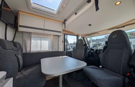 Intérieur d'un camping-car moderne avec table et sièges rembourrés