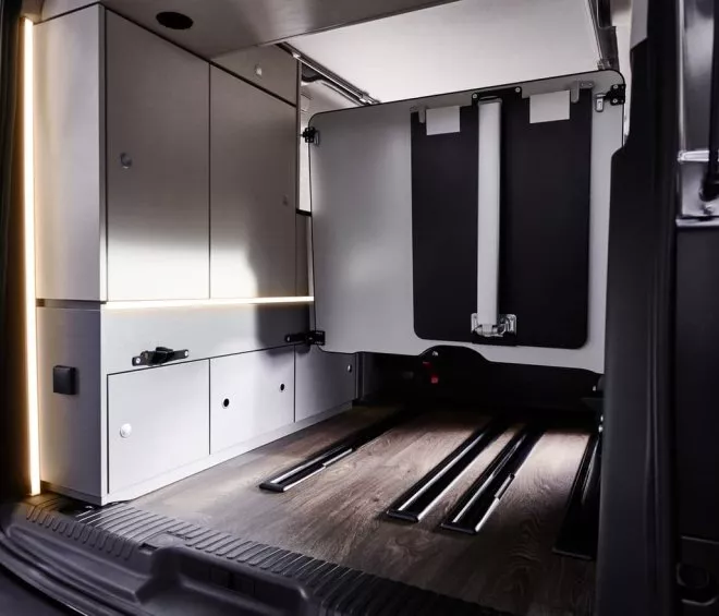 Intérieur d'un van aménagé avec rangements et plancher en bois