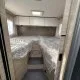 Intérieur d'une caravane avec lits jumeaux et rangements en bois clair.