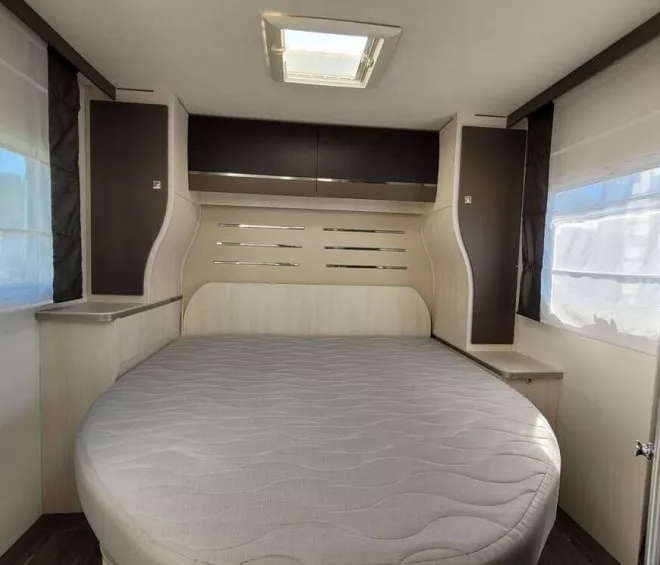 Intérieur d'une caravane avec lit rond et placards intégrés