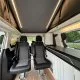 Intérieur d'un van aménagé avec sièges pivotants et éclairage LED