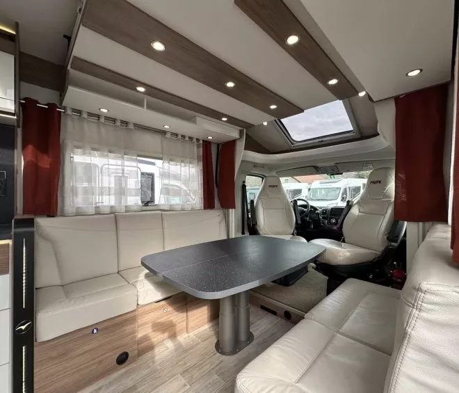 Intérieur d'un camping-car avec table et sièges en cuir beige