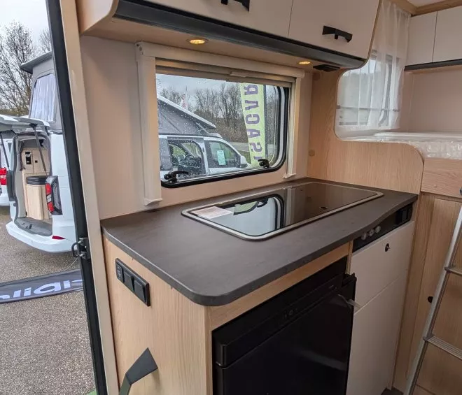 Cuisine moderne de camping-car avec plaque de cuisson et rangements