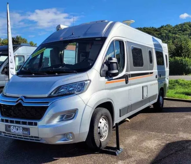 Camping-car Citroën gris stationné sur un parking ensoleillé