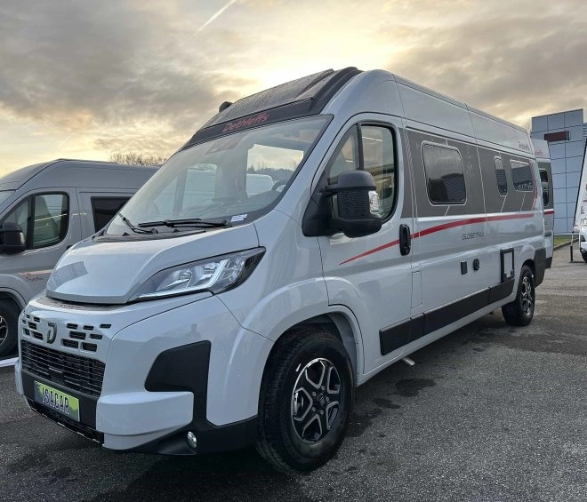 Camping-car Dethleffs Globetraveller stationné sur un parking au coucher du soleil.
