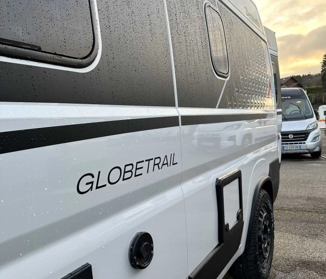 Camping-car Globetrail stationné sous un ciel nuageux, vue latérale.