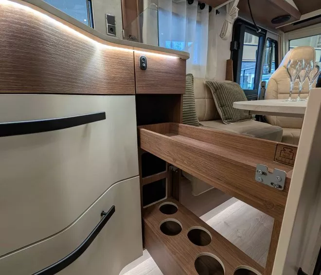 Intérieur d'un camping-car avec rangement en bois et sièges en cuir beige