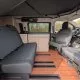 Intérieur d'un van aménagé avec sièges et kitchenette en bois clair