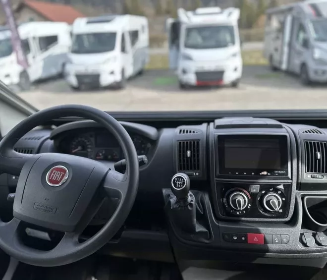Tableau de bord d'un camping-car Fiat avec vue sur d'autres véhicules stationnés