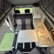 Intérieur d'un van aménagé avec table, sièges et kitchenette