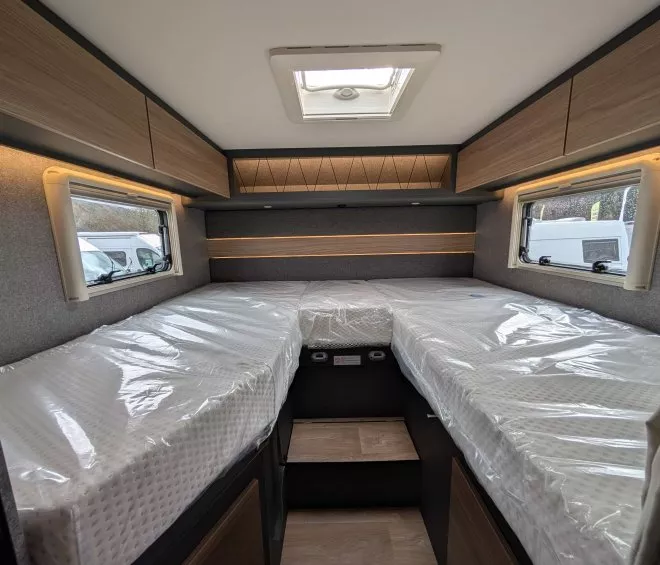 Intérieur d'un camping-car avec lits jumeaux et rangements en bois