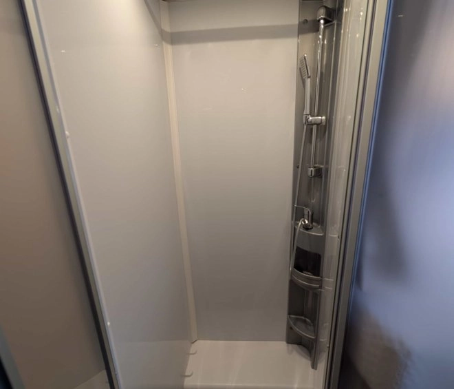 Cabine de douche moderne avec sol en bois et parois blanches