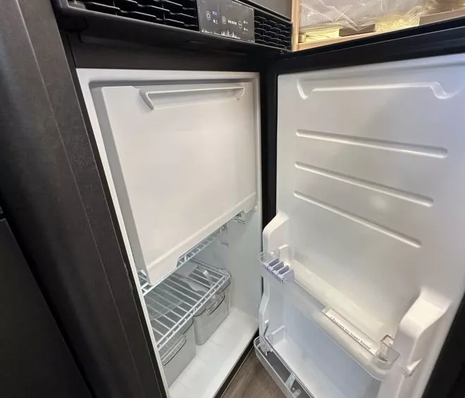 Réfrigérateur ouvert avec étagères et bacs de rangement visibles