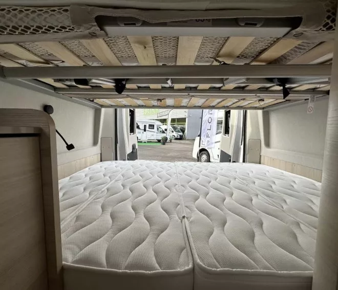 Intérieur d'un camping-car avec lit double et sommier visible