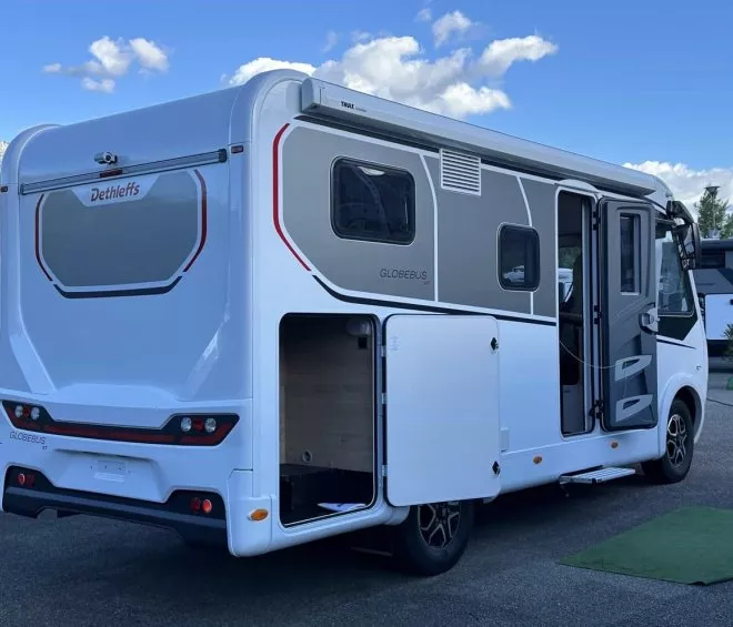 Camping-car Dethleffs Globebus GT stationné sur un parking, ciel bleu en arrière-plan.