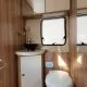 Salle de bain compacte en bois avec lavabo et toilettes dans un camping-car.
