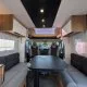 Intérieur spacieux d'un camping-car moderne avec table et banquettes grises