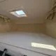 Espace couchage avec matelas et hublot dans un camping-car moderne