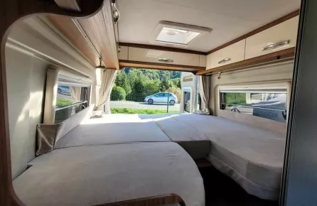 Intérieur d'un camping-car avec lit double et vue sur la route