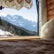 Vue montagne depuis l'intérieur d'un van aménagé, avec lit et coussin