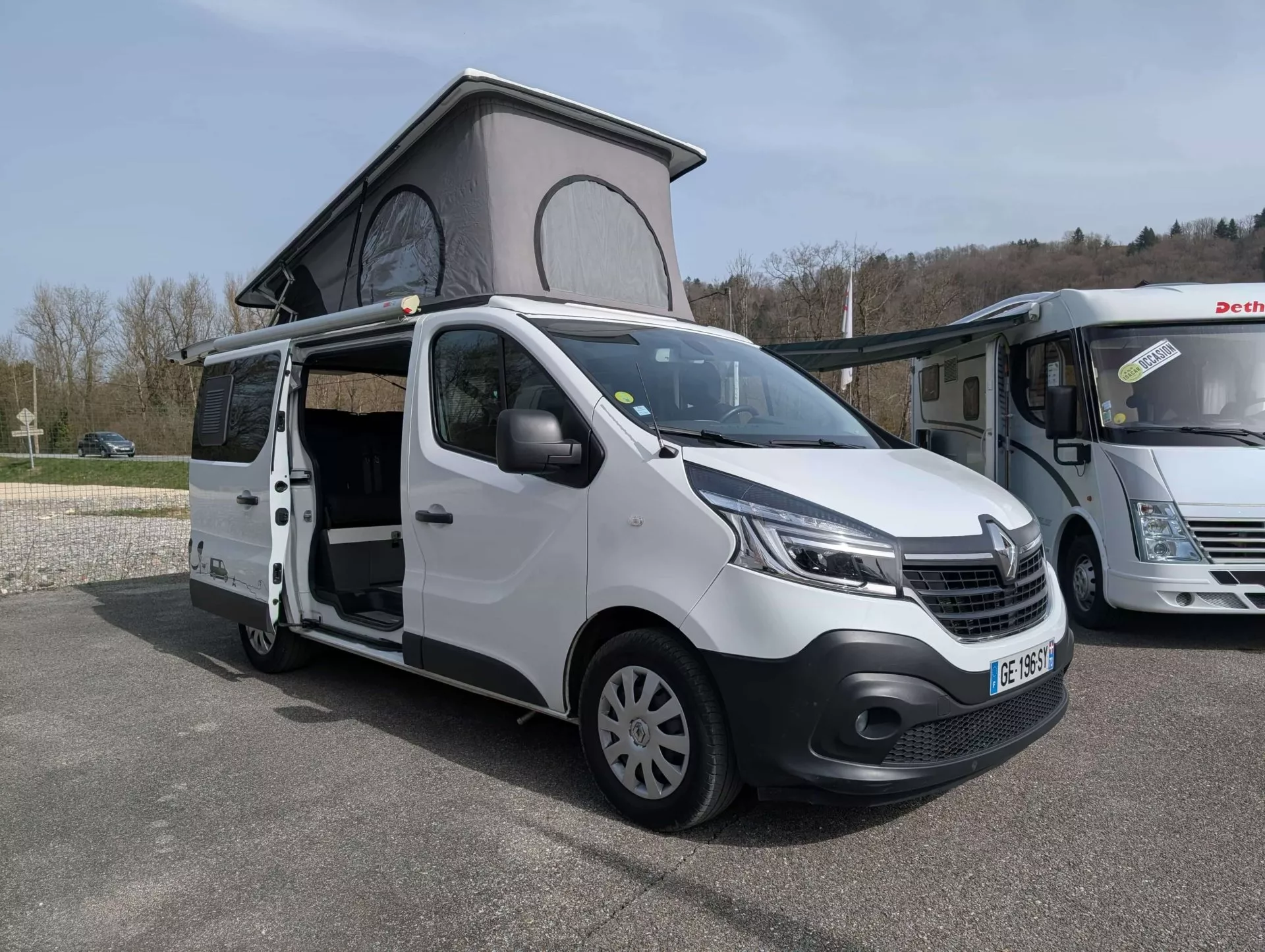 Fourgon aménagé Renault avec toit relevable sur aire de stationnement