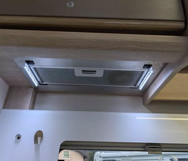 Hotte aspirante encastrée avec éclairage LED sous meuble de cuisine en bois clair