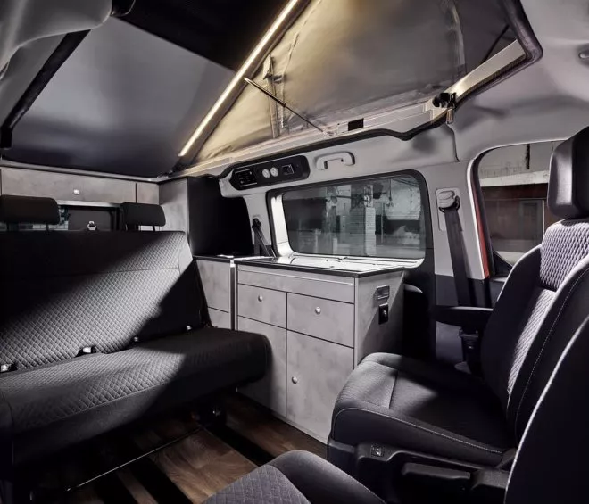 Intérieur d'un van aménagé avec sièges et kitchenette moderne