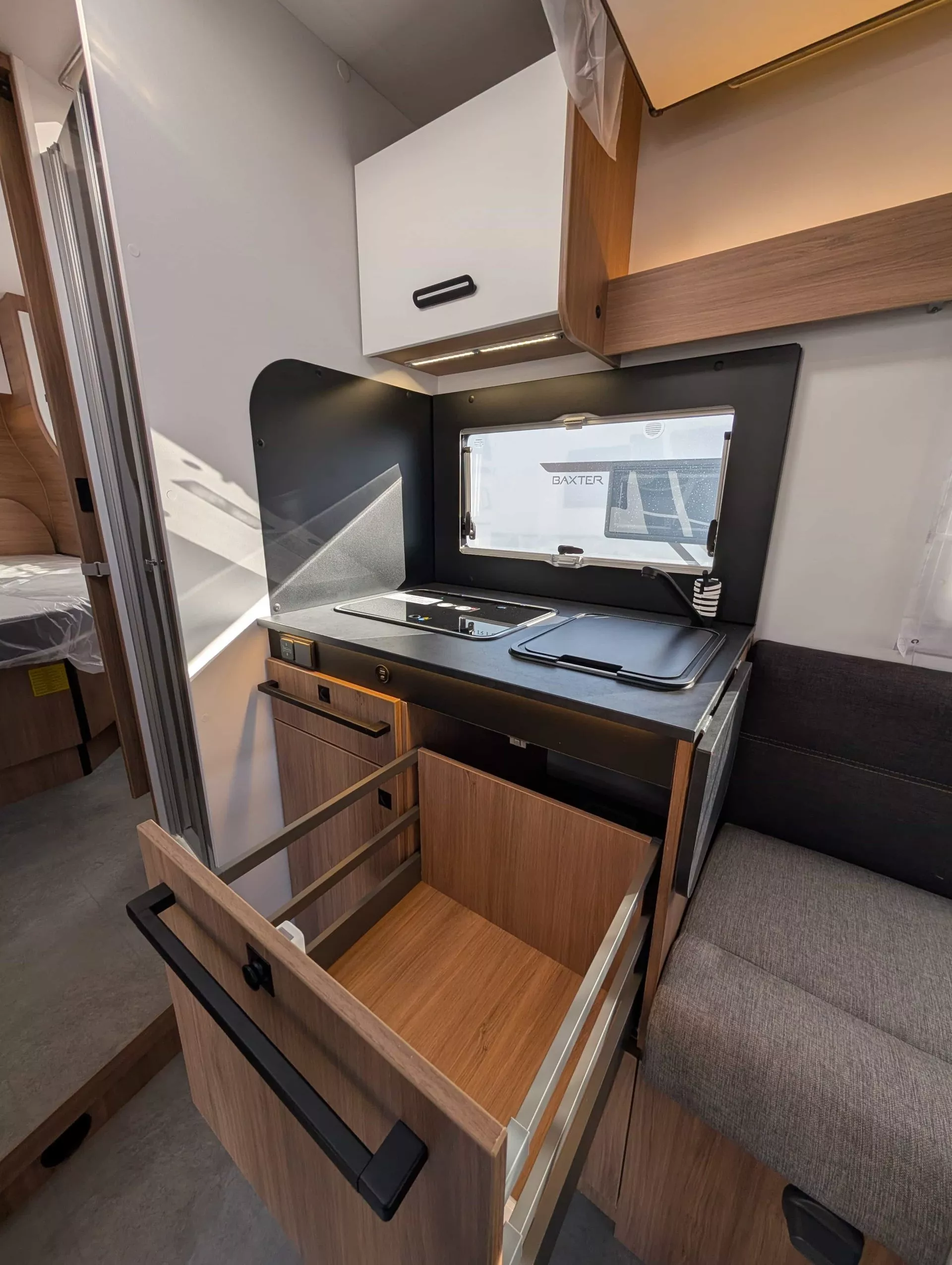 Cuisine compacte de camping-car avec tiroir ouvert et plaque de cuisson