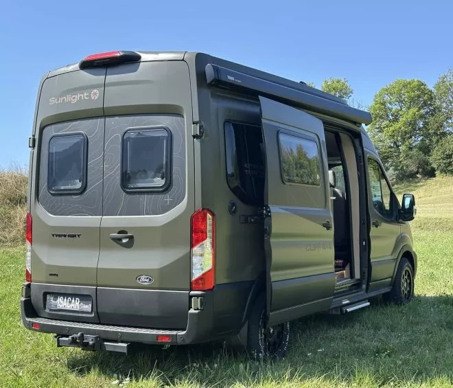 Camping-car Sunlight Cliff 4x4 stationné dans un champ verdoyant sous un ciel bleu