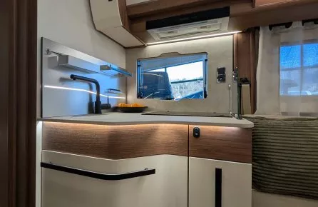 Cuisine moderne d'un camping-car avec évier et rangements intégrés