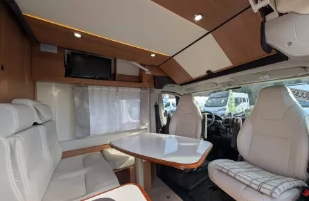 Intérieur d'un camping-car avec table et sièges en cuir beige